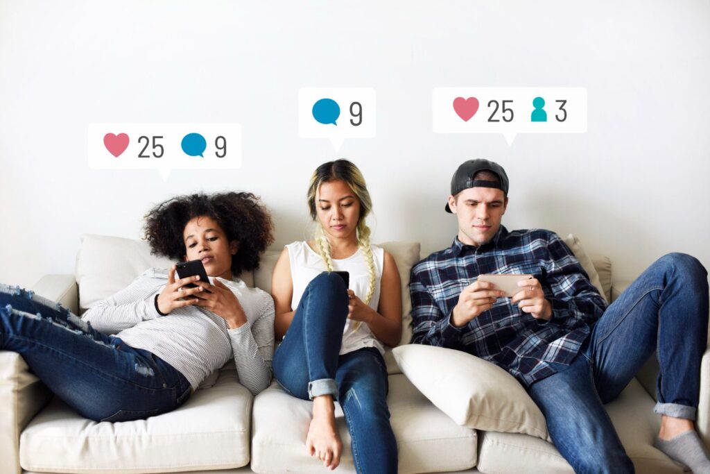 young adults on the couch using social media on their smartphones Des jeunes assis sur le canapé en manipulant leurs smartphones